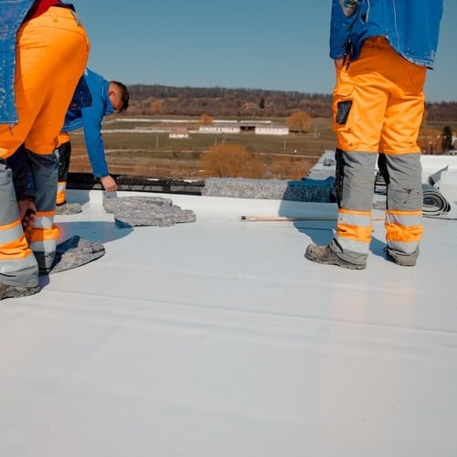Roofers install TPO.
