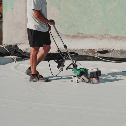 Roofer applies TPO.